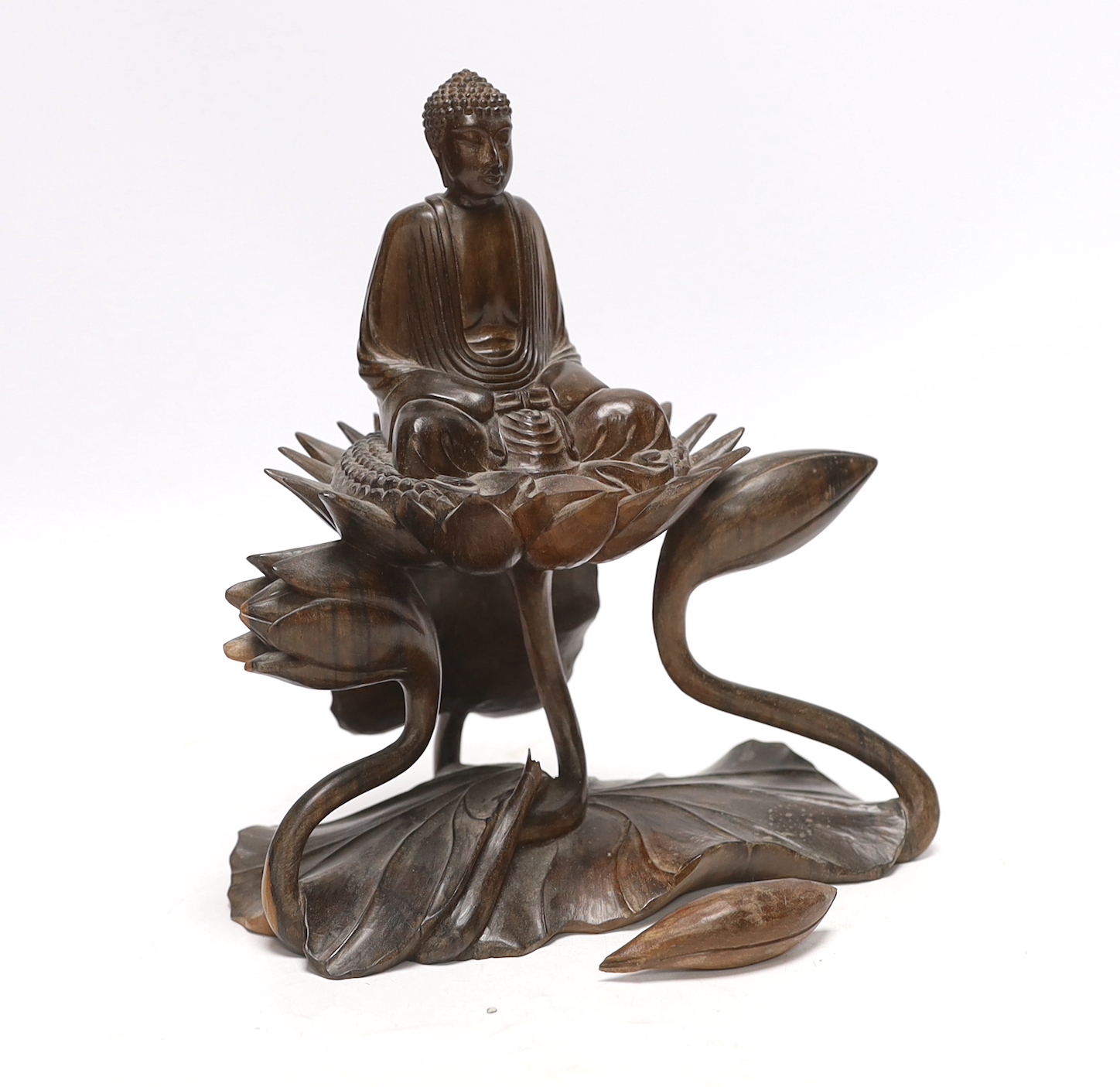 A Thai carved hardwood model of a Buddha on a lotus, damaged, loose piece, 22cm